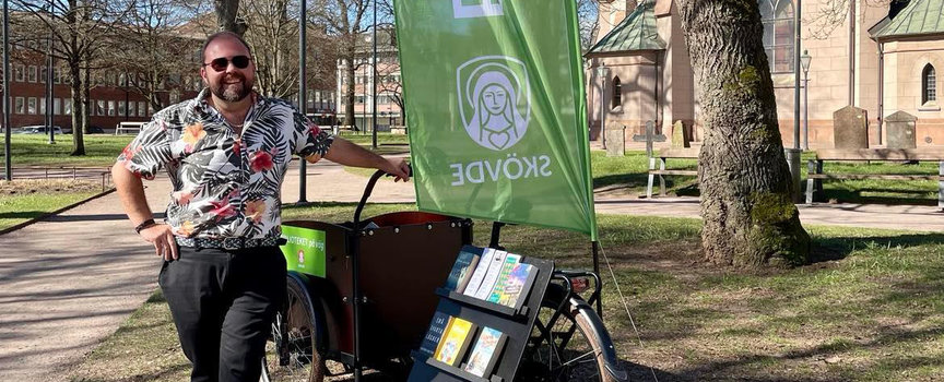 Bild på en man med bibliotekets bokcykel
