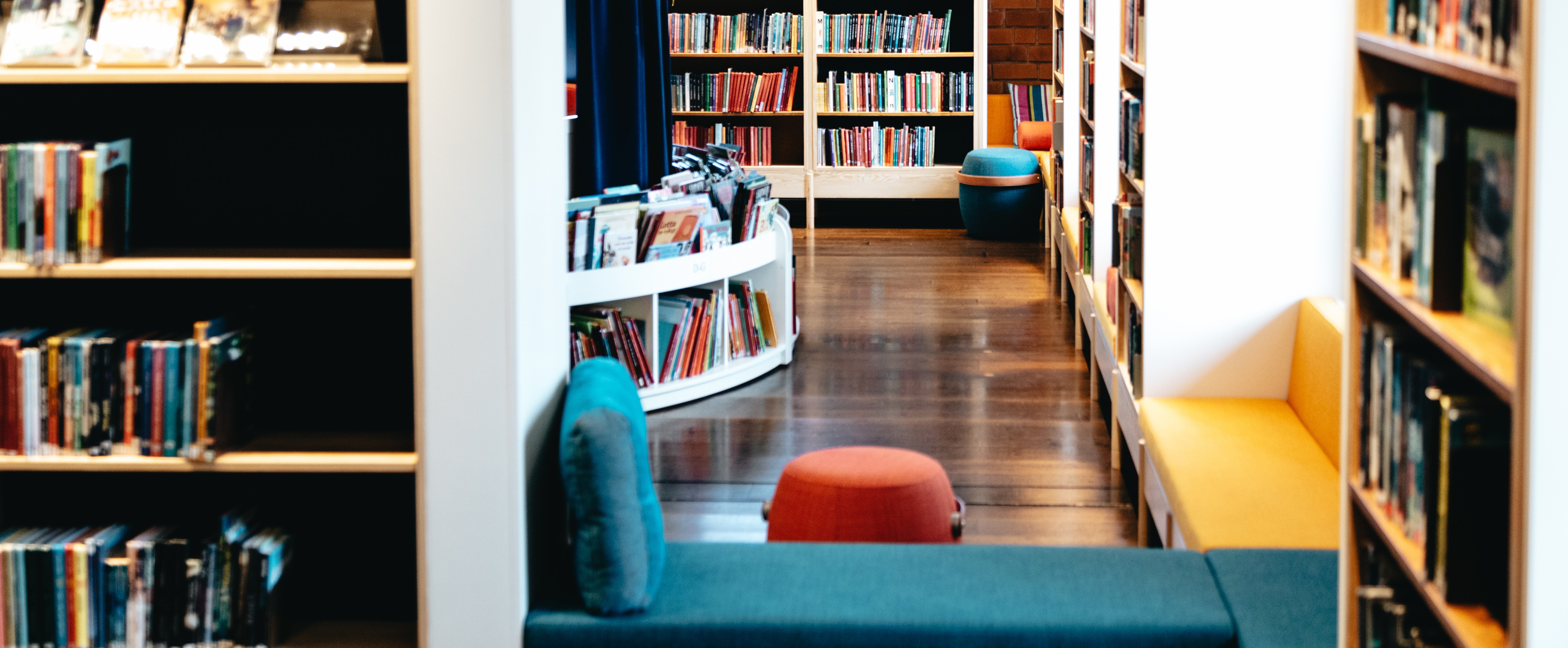 Bibliotekets barnavdelning med flera hyllor och soffor.